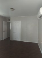 A room with a white door and a window.